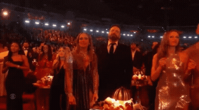 A Group Of People Standing In A Dark Room With A Cbs Logo On The Bottom Right GIF
