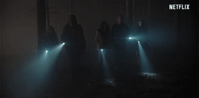 A Group Of People Standing In A Dark Room With A Netflix Logo In The Background GIF