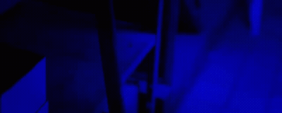 A Group Of People Standing In A Dark Room With Glow In The Dark Paint GIF