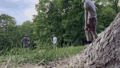 A Group Of People Standing In A Grassy Field GIF
