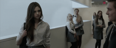 A Group Of People Standing In A Hallway With A Sign That Says Exit On It GIF