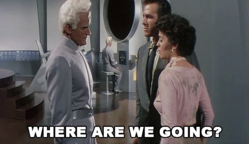 A Group Of People Standing In A Room With The Words " Where Are We Going " Above Them GIF