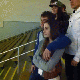 A Group Of People Standing In A Stadium With One Wearing A Hat That Says Nyc GIF