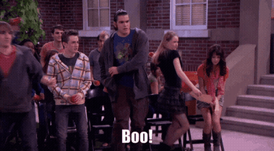 A Group Of People Standing In Front Of A Brick Building With The Word Boo Written On The Bottom GIF