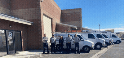 A Group Of People Standing In Front Of A Building With Vans Parked In Front Of Them That Say All Kinds Of Plumbing GIF