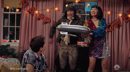 A Group Of People Standing In Front Of A Halloween Banner That Says " Happy Halloween " GIF