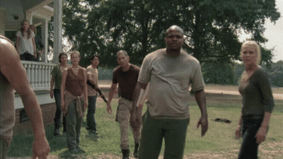 A Group Of People Standing In Front Of A House In A Field GIF