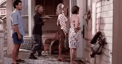 A Group Of People Standing In Front Of A House . GIF