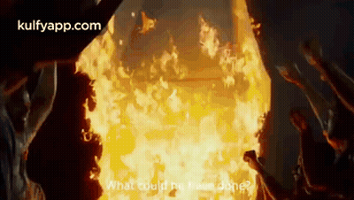 A Group Of People Standing In Front Of A Large Fire . GIF