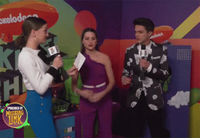A Group Of People Standing In Front Of A Nickelodeon Logo GIF