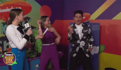A Group Of People Standing In Front Of A Nickelodeon Sign GIF