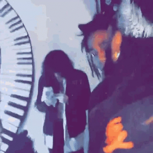 A Group Of People Standing In Front Of A Piano Keyboard . GIF