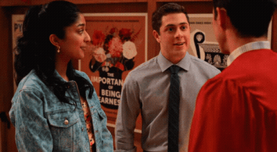 A Group Of People Standing In Front Of A Poster That Says The Important Of Being Earnest GIF