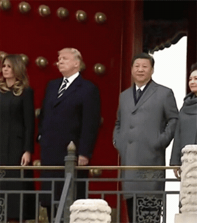A Group Of People Standing In Front Of A Red Wall GIF