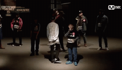 A Group Of People Standing In Front Of A Sign That Says ' Show Me The Money ' GIF