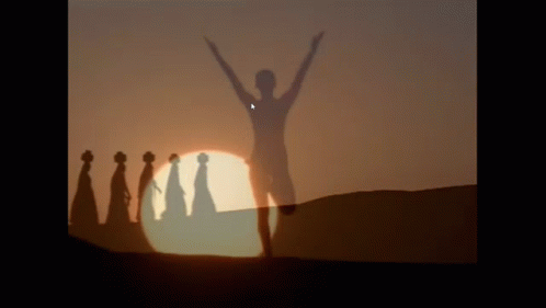 A Group Of People Standing In Front Of A Sunset GIF