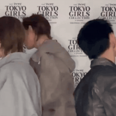A Group Of People Standing In Front Of A Wall That Says Tokyo Girls GIF