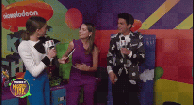 A Group Of People Standing In Front Of A Wall With A Nickelodeon Logo On It GIF