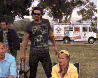 A Group Of People Standing In Front Of A White Food Truck GIF