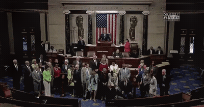 A Group Of People Standing In Front Of An American Flag With A Sign That Says Nightly Fn News GIF