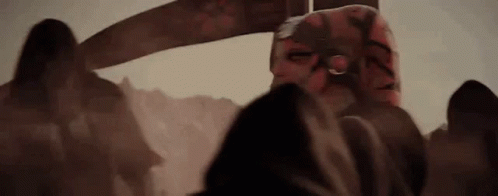 A Group Of People Standing Next To Each Other In A Dark Room With A Sword In The Background . GIF