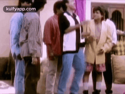 A Group Of People Standing Next To Each Other In A Living Room . GIF