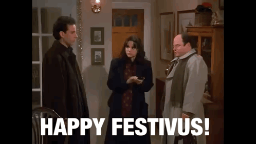 A Group Of People Standing Next To Each Other In A Living Room With The Words `` Happy Festivus '' Written On The Screen GIF