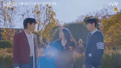 A Group Of People Standing Next To Each Other In A Park With Trees In The Background . GIF