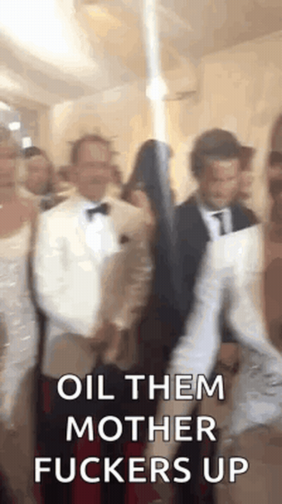 A Group Of People Standing Next To Each Other In A Room With The Words `` Oil Them Mother Fuckers Up '' Written On The S GIF