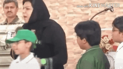 A Group Of People Standing Next To Each Other In Front Of A Brick Wall . GIF