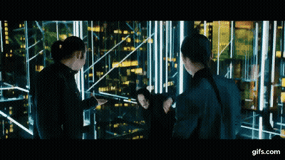 A Group Of People Standing Next To Each Other In Front Of A Building . GIF