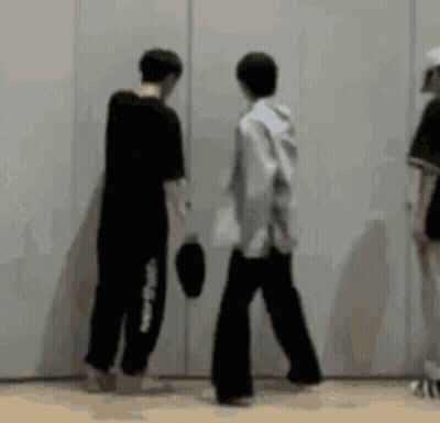 A Group Of People Standing Next To Each Other In Front Of A White Wall . GIF
