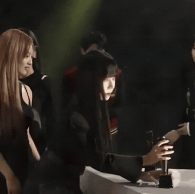 A Group Of People Standing Next To Each Other On A Stage . GIF