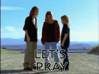 A Group Of People Standing On A Dirt Road With The Words Let 'S Pray GIF