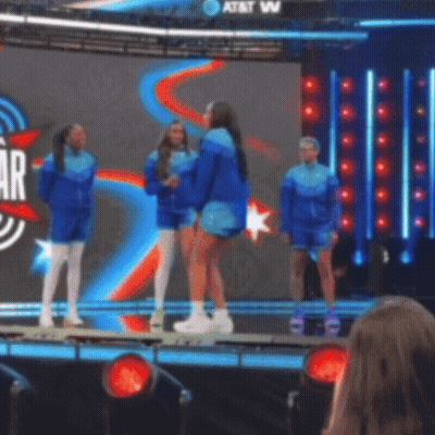 A Group Of People Standing On A Stage In Front Of A Screen That Says At & T GIF