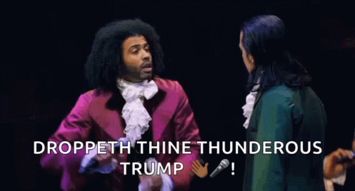 A Group Of People Standing On A Stage With A Microphone In Front Of Them And The Words Droppeth Thine Thunderous Trump . GIF