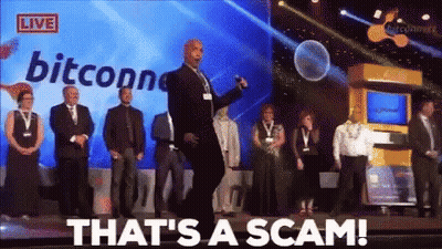 A Group Of People Standing On A Stage With The Words That 'S A Scam On The Screen Behind Them GIF