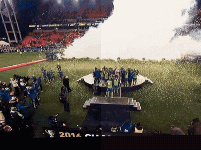 A Group Of People Standing On A Stage With The Year 2014 On The Bottom Left GIF