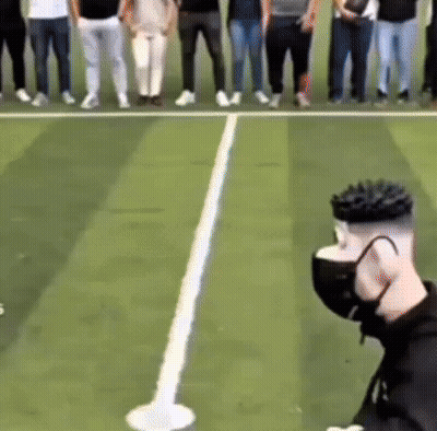 A Group Of People Standing On A Tennis Court With A Person Wearing A Mask GIF