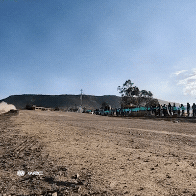 A Group Of People Standing On The Side Of A Dirt Road With The Word Fia On The Bottom Right GIF