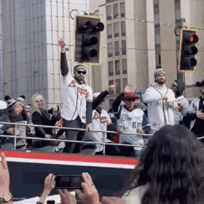 A Group Of People Standing On Top Of A Bus In A Parade . GIF