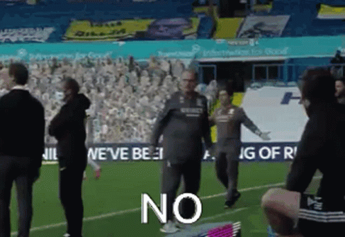 A Group Of People Standing On Top Of A Soccer Field With The Word No Written On The Ground . GIF