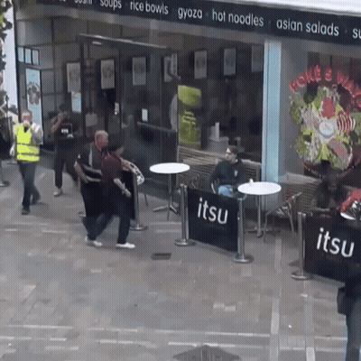 A Group Of People Standing Outside Of A Restaurant Called Jitsu GIF