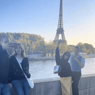 A Group Of People Taking A Picture Of The Eiffel Tower In Paris GIF