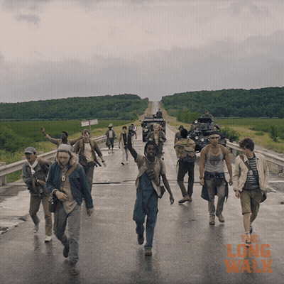 A Group Of People Walking Down A Road With The Long Walk Written On The Bottom Right GIF