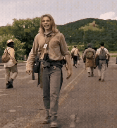 A Group Of People Walking Down A Street With A Man Wearing A Name Tag That Says A On It GIF