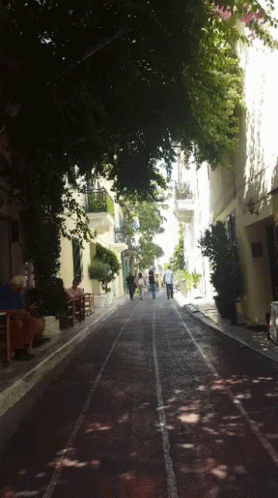 A Group Of People Walking Down A Street With A Sign That Says ' A ' On It GIF