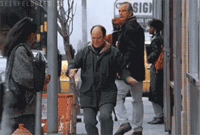 A Group Of People Walking Down A Street With A Sign That Says Sign GIF