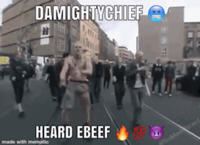 A Group Of People Walking Down A Street With The Words Damightychief Heard Ebeef On The Bottom GIF