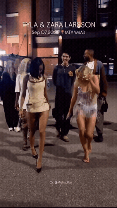 A Group Of People Walking Down A Street With The Words Tyla & Zara Larsson Written On The Bottom GIF